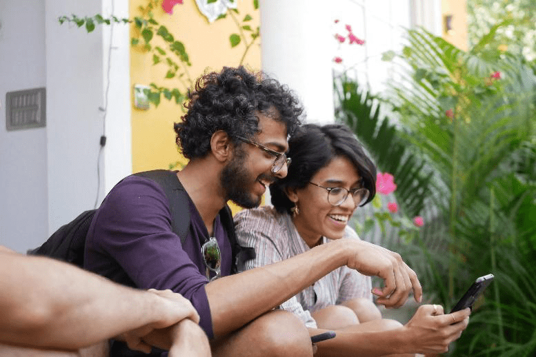two people sitting outdoors using smartphone with VPN connection active