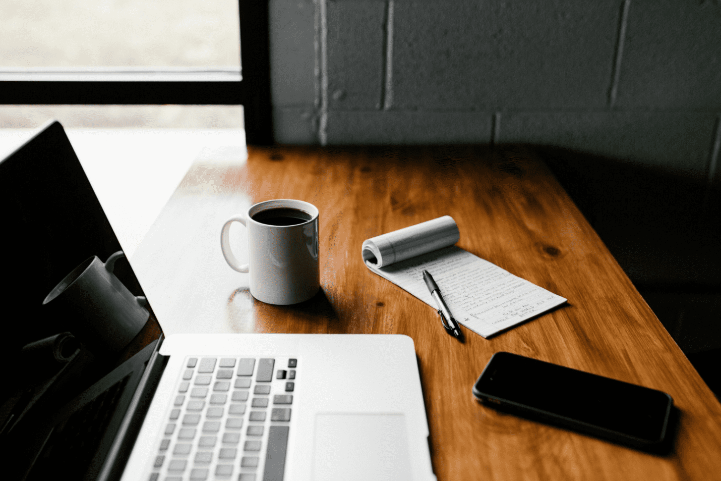 A cup of coffee next to an open laptop