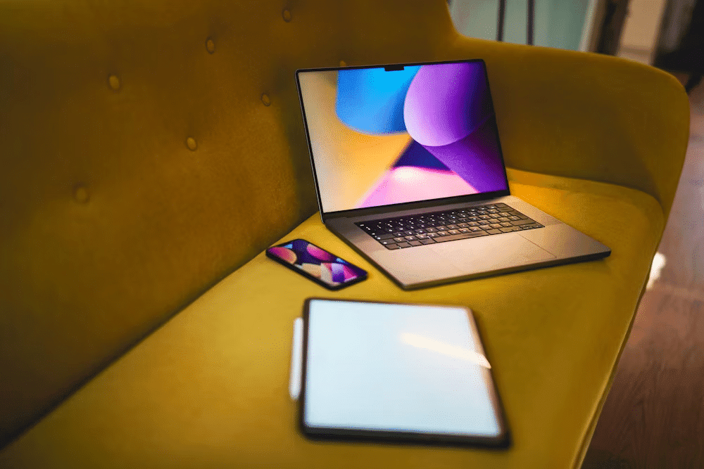 A laptop on a yellow couch