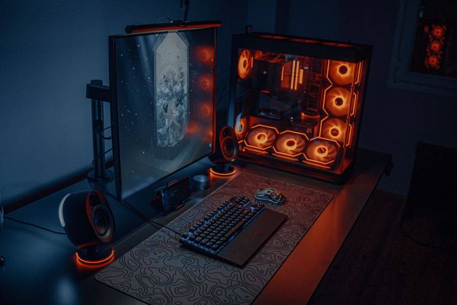 Gaming PC setup with illuminated components and monitor, illustrating cybersecurity and gaming technology.