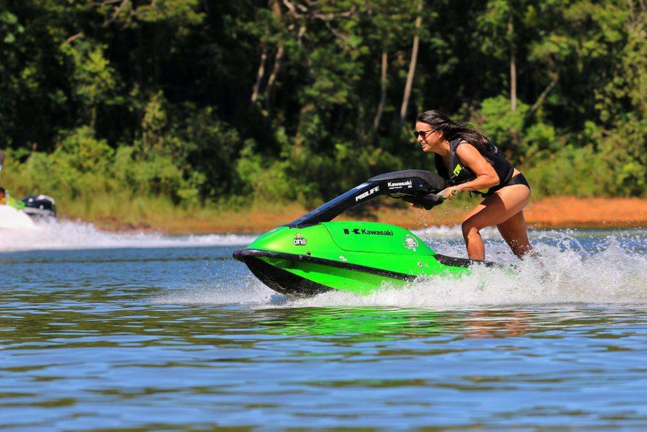Woman riding Kawasaki jet ski on water, illustrating online freedom and bypassing geo-restrictions.