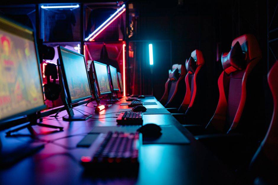 Gaming setup with multiple monitors and ergonomic chairs, illustrating VPN use for console gaming.